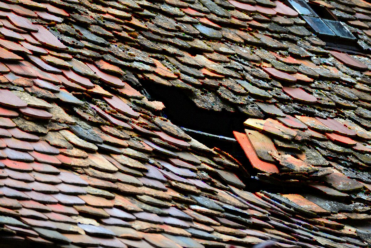 A hole worn through roof covering, exposing the underlayment beneath