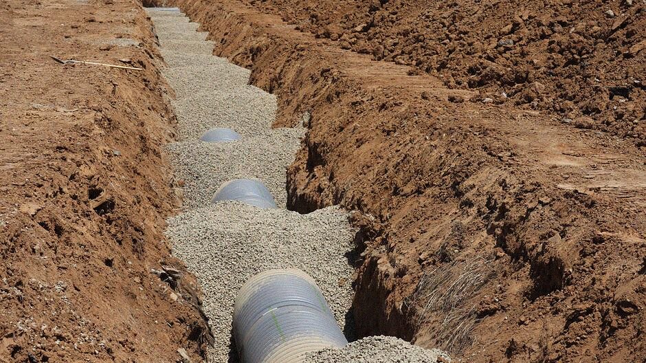 A sewer lateral pipe laid in an open excavation trench